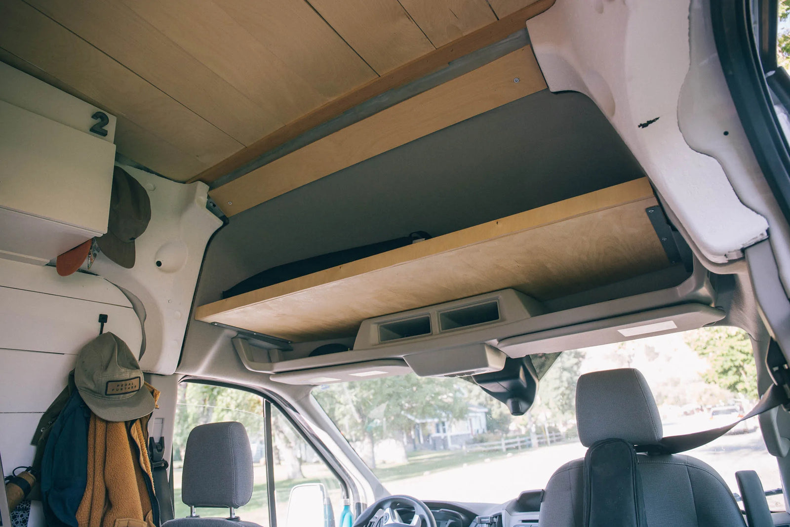 Headliner shelf above the front seats of a ford transit camper van