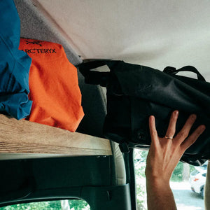 headliner shelf storage in sprinter van containing jackets and a laptop bag, easily accessible